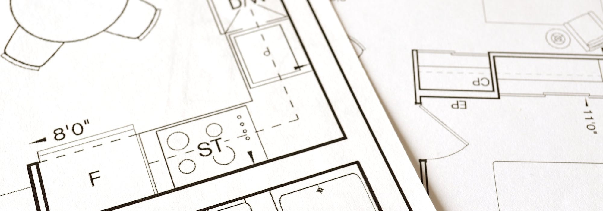 Close-up view of an architectural floor plan on paper showcasing detailed room layouts and measurements.